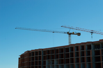 two cranes on a blue sky background