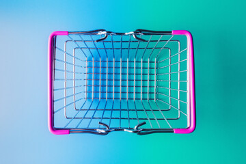 Empty shopping basket over turquoise-blue background. Top view