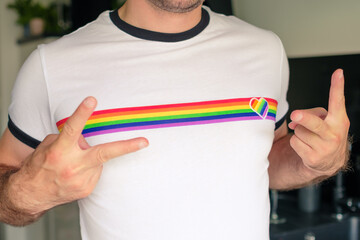 Man in the T shirt with LGBT flag shows sign Peace. Gay and lesbian rights concept. 