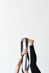 closeup of woman's hands and feet practicing yoga with bands exercising in gym graceful