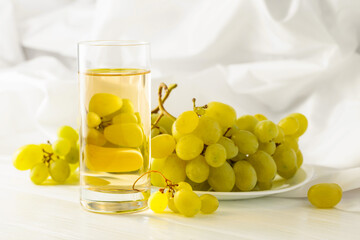 Glass of grape juice and grape cluster.