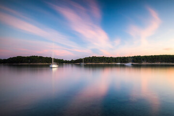 Boats at the bay of Eufemija on island of Rab Croatia with long exposure clouds in the sky