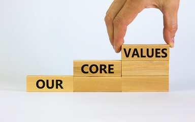 Our core values symbol. Concept words 'Our core values' on wooden blocks on a beautiful white background. Businessman hand. Business and our core values concept. Copy space.