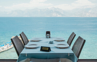Fototapeta premium A table in a restaurant or a summer cafe on the sea coast of Antalya, Turkey. Place in a restaurant with a wonderful sea view.