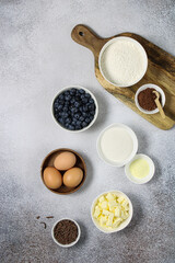 Set of products for baking desserts. Ingredients for baking homemade muffins on a light background copy space. Recipe for baking chocolate muffins with berries step by step