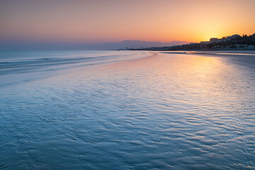 Obraz premium calm sunrise with reflections on the beach with copy space