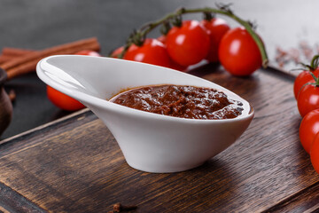 Red sauce or ketchup in a bowl and ingredients for cooking