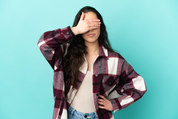 Young caucasian woman isolated on blue background covering eyes by hands. Do not want to see something