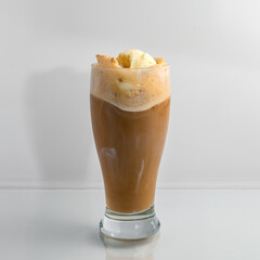 Delicious soda fountain style old fashioned frothy Root Beer Float in a clear glass on a white background.
