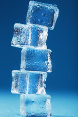 Cubes of melting ice tower on a blue background.