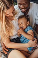 Mixed race family relaxing on bed together at home