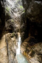 deep gorge with rocks and turquoise white water creek passing