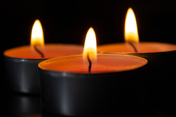 Composition of three candles on dark luxury night background. Black table, side view. Candles...