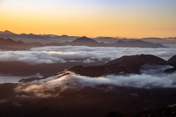 Sunrise reveals clouds rolling over Australian mountains