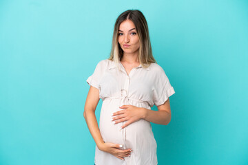Young Romanian woman isolated on blue background pregnant