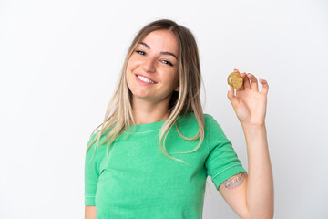 Young Romanian woman holding a Bitcoin isolated on white background smiling a lot