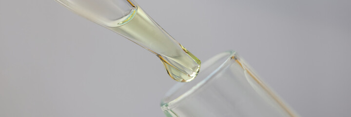 White-golden liquid is dripped from pipette into test tube