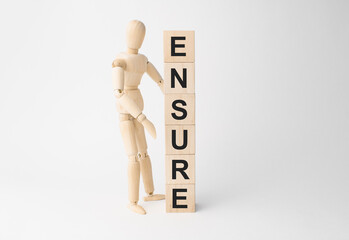 Wooden mannequin near tower of cubes with word ensure on table against light background