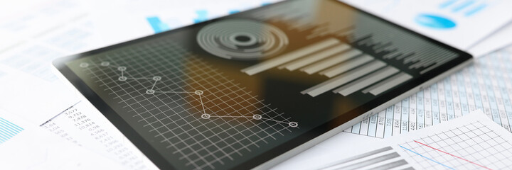 Tablet with business indicators in charts is on desktop
