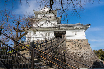 Steps to white Japanese tower, Odawara Castle. Bare winter trees in Japan.