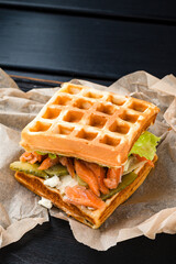 Belgian waffle with salmon on wood table. Keto Breakfast variation.
