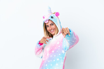 Blonde Uruguayan girl wearing a unicorn pajama isolated on white background pointing to the front and smiling