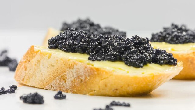 Close-up of canapes with butter and black caviar.