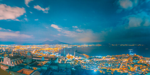 Naples, Italy. Skyline Cityscape In Evening Lighting. Tyrrhenian Sea And Landscape With Volcano Mount Vesuvius. City In Night Illuminations