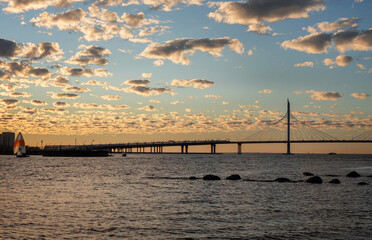 Fototapeta na wymiar Sunset over the bay with sailboats and a view of the bridge