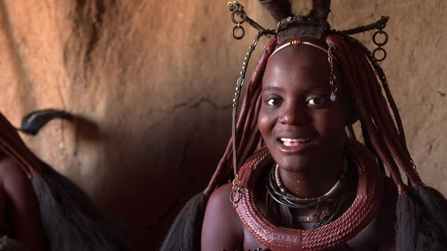 Young Himba woman inside her hut at traditional Himba village near Kamanjab in Namibia, Africa.