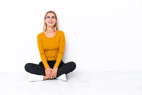 Blonde Uruguayan girl sitting on the floor laughing