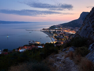 City of Omis by night. Evening panorama of the Croatian seaside resort. Blue hour.
