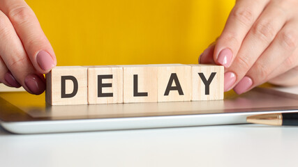 woman made word delay with wooden blocks, concept