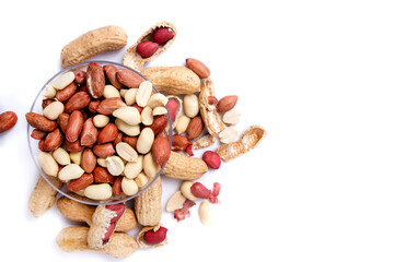 Peanut butter isolated and peanuts in the peel scattered on the white background. Copy space.