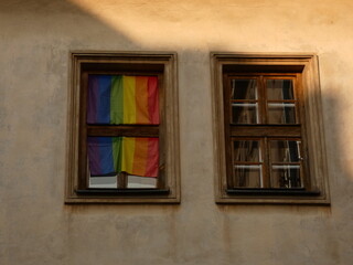 Obraz premium Rainbow flag in the window with wooden frames, Kraków, Poland
