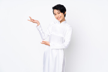Young Vietnamese woman with short hair wearing a traditional dress over isolated white background...
