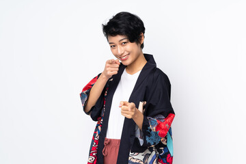 Young Vietnamese woman with short hair wearing a traditional dress over isolated white background points finger at you with a confident expression