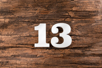 thirteen 13 - White wooden number on rustic background