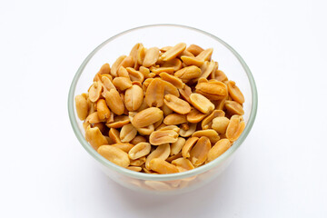 Peeled peanuts in glass bowl on white background.