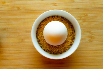 A single lemon in a cup with brown sugar