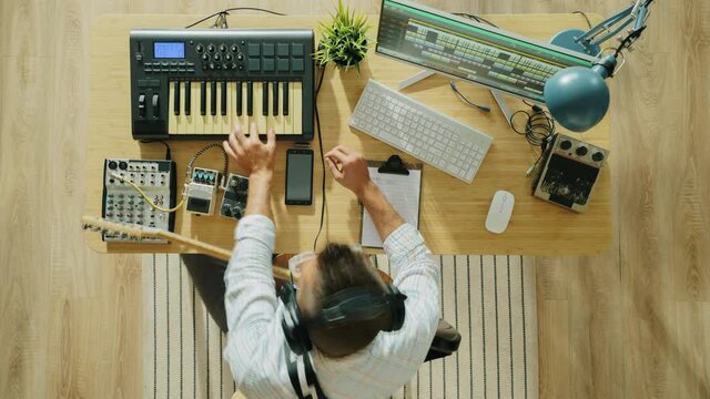 Time lapse of professional musician recording music playing electric guitar and keyboard using modern equipment in studio. Creative youth and technology concept.