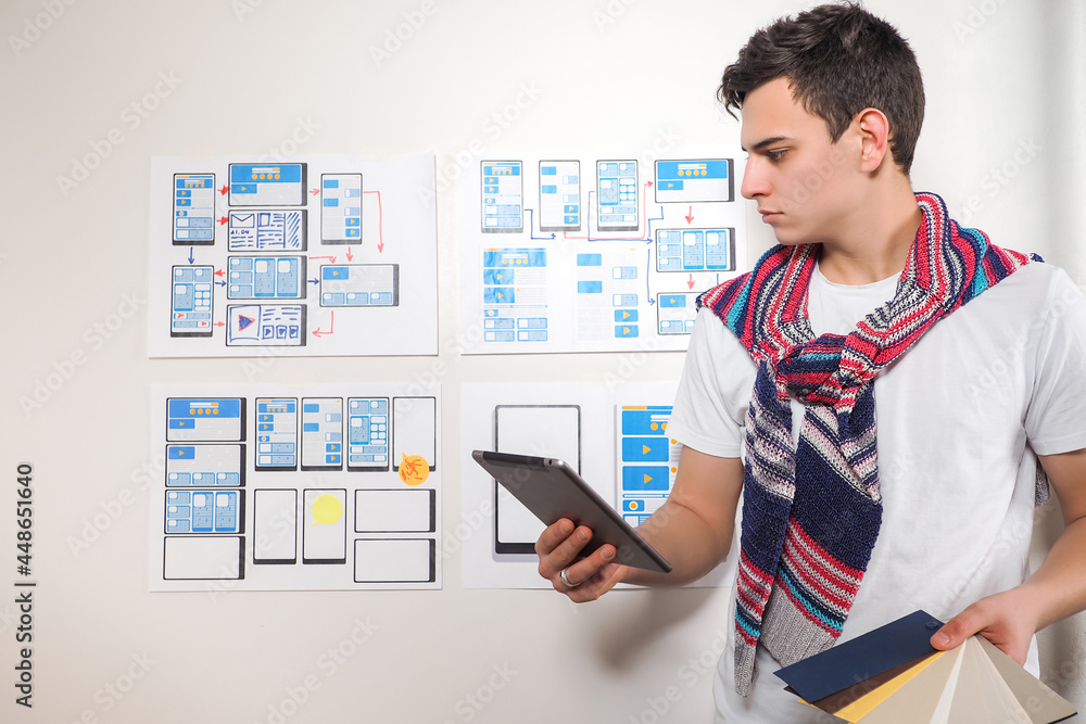 Poster manager in the application development studio. young guy works in a web studio. developer portrait n