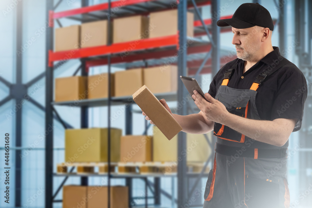 Poster warehouse technology concept. man with tablet and a box. warehouse worker looks into tablet. he uses
