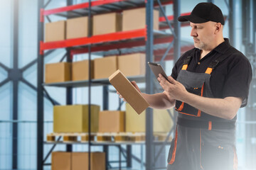 Warehouse technology concept. Man with tablet and a box. Warehouse worker looks into tablet. He...