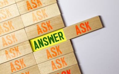 Concept word ASK and ANSWER on wooden blocks on beautiful background from green flower.