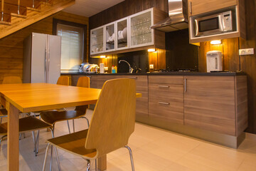 Interior dining room made of wood materials. interior dining design. Dining room furniture is made in same style. Interior of the room is done in natural colors. Modern cottage kitchen.