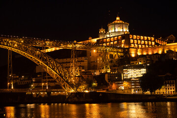 Night shot of Porto looking towards Vila Nova de Gaia, with the illuminated "Ponte Dom Luís I" bridge, the Serra do Pilar monastery, and the old port wine cellars along the Douro River, Portugal