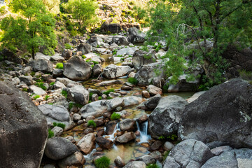 Granite boulders in the Fafião river, a popular bathing and swimming spot, Peneda-Gerês National Park, Braga district, Portugal