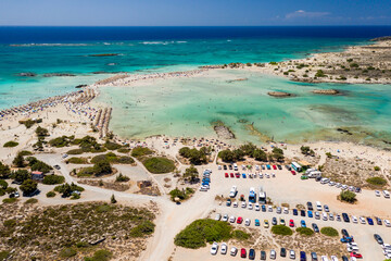 Aerial view of a beautiful but busy sandy beach and shallow lagoons surrounded by clear, blue ocean (Elafonissi, Crete)