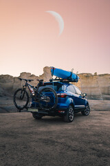 blue suv with bike and kayak off-road